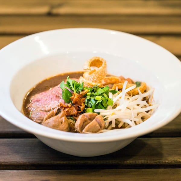 A Kao Sarn Thai Street Food noodle dish with beef, meatballs, bean sprouts, and herbs.